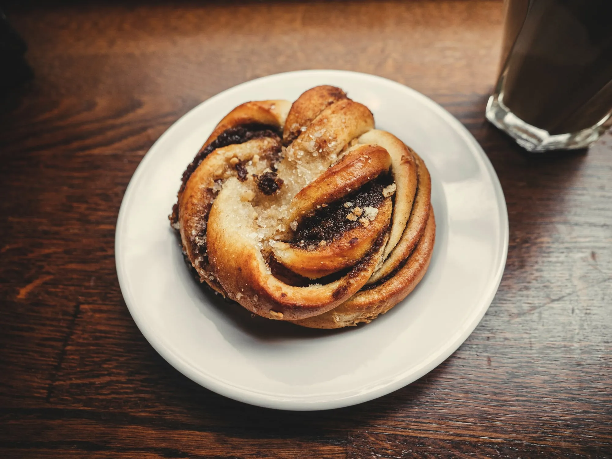A knotted cardamom bun on a white plate