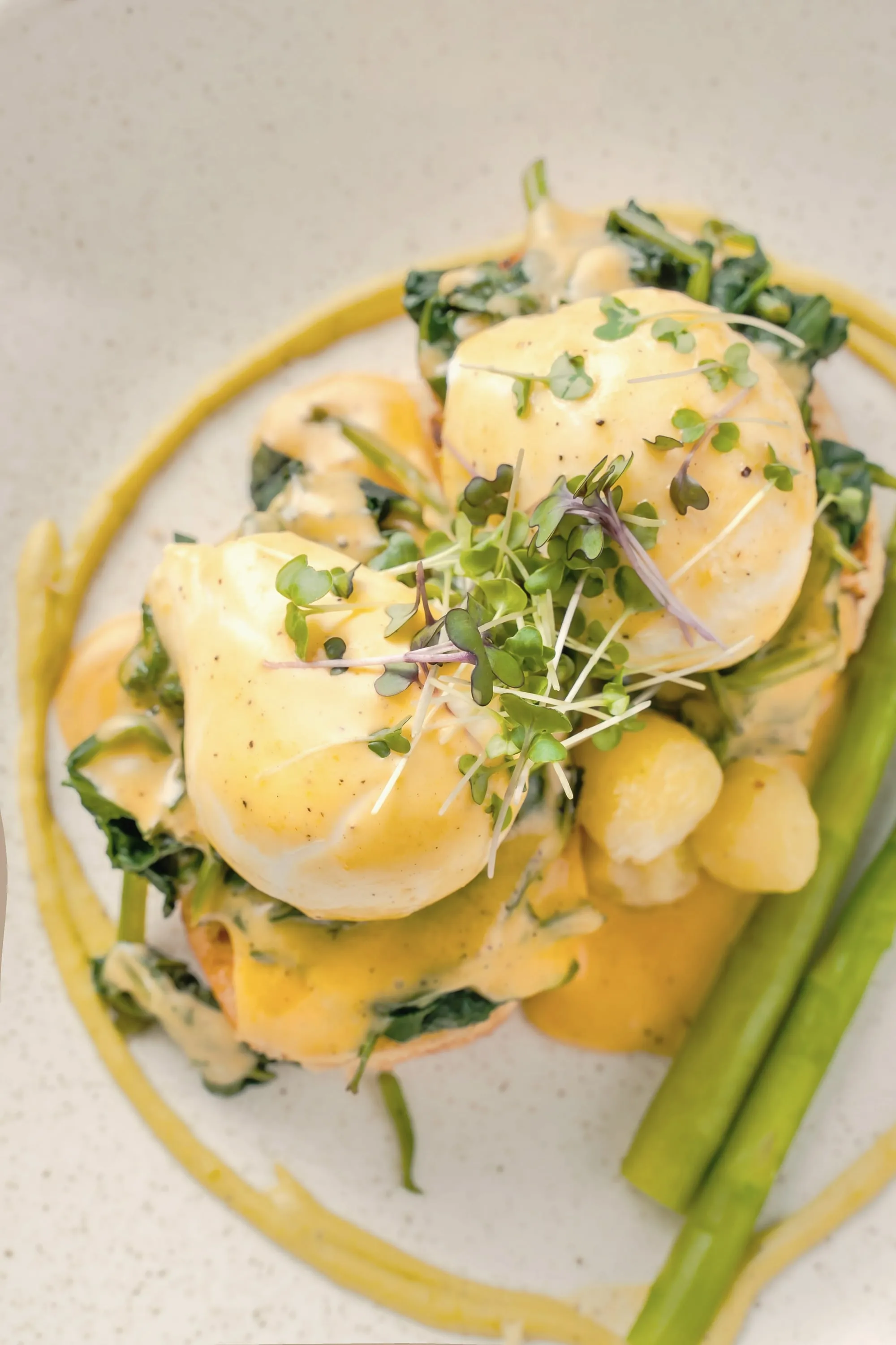 Eggs benedict with hollandaise, asparagus and micro herbs